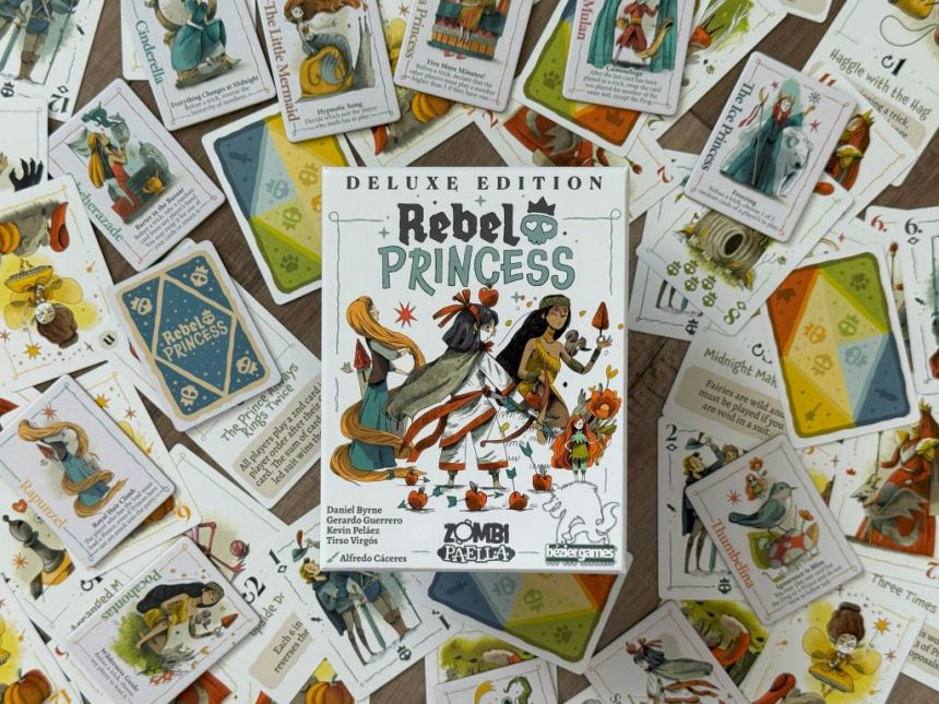 Game box featured surrounded by game components, including suit and round cards along with princess tiles.